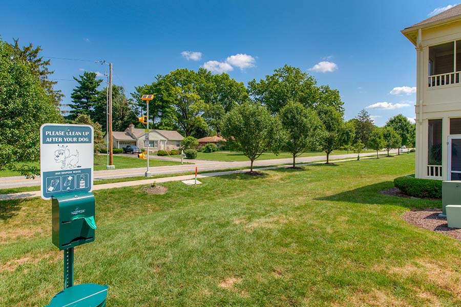 Dog park with a sign and complementary waste bags located at Stonebridge apartments.