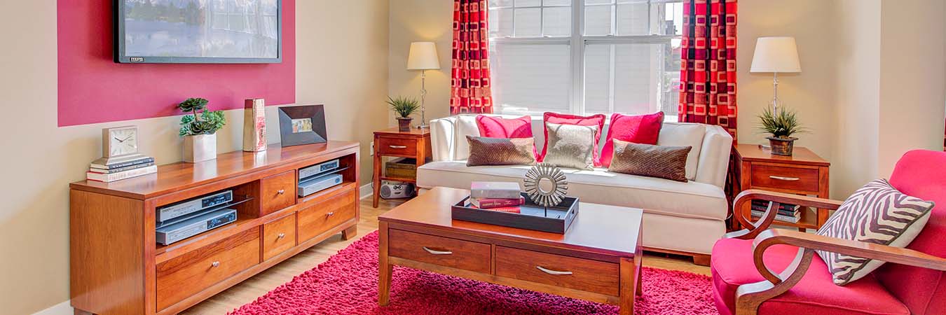 A living room at Waverly Apartments with bright pink decor
