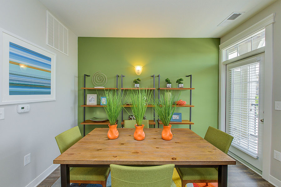 Vibrant green and orange decor in a dining room area located at Lakeside apartments.