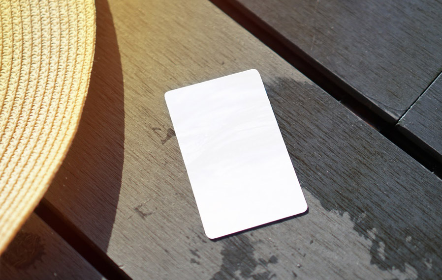 Don't forget your pool pass to to take a refreshing swim at Highpointe on Meridian Apartments. Summer hat and key card on a deck floor.