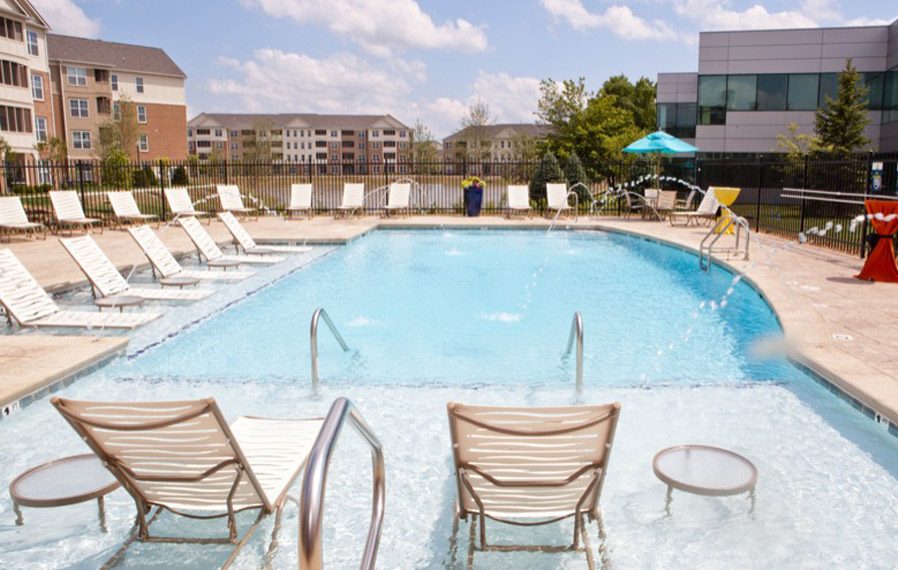 A beautiful blue pool enhances your apartment experience in Carmel. Lake side pool on a sunny day.